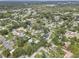 An aerial view shows a neighborhood with mature trees and varying home styles on a sunny day at 8701 N Packwood Ave, Tampa, FL 33604