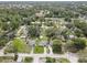 This aerial view shows a residential neighborhood, highlighting mature trees and a mix of home designs at 8701 N Packwood Ave, Tampa, FL 33604
