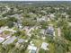 An aerial view shows a neighborhood with mature trees and varying home styles on a sunny day at 8701 N Packwood Ave, Tampa, FL 33604