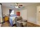 Bedroom with a ceiling fan, wood-look floors, a window, and an accent chair at 8701 N Packwood Ave, Tampa, FL 33604