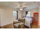 Cozy bedroom features wood-look flooring, a ceiling fan, and a comfortable chair at 8701 N Packwood Ave, Tampa, FL 33604
