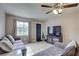 Bright living room with a grey sofa, ceiling fan, a front door and a TV on a stand at 8701 N Packwood Ave, Tampa, FL 33604