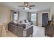 Inviting living room with tile floors, a ceiling fan, two grey sofas and natural lighting through two windows at 8701 N Packwood Ave, Tampa, FL 33604