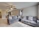 Spacious living room featuring neutral walls, tile flooring, a ceiling fan, and two grey sofas at 8701 N Packwood Ave, Tampa, FL 33604
