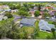Aerial view of a home with a large backyard, fire pit and mature trees in a quiet neighborhood at 8823 Aruba Ln, Port Richey, FL 34668
