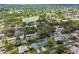 Expansive aerial shot of a community featuring homes surrounded by lush greenery and a tranquil lake at 8823 Aruba Ln, Port Richey, FL 34668