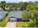 Aerial view of single-Gathering home featuring a well-manicured lawn and mature trees at 8823 Aruba Ln, Port Richey, FL 34668