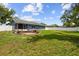 Spacious backyard with a large, well-maintained lawn and a charming brick firepit at 8823 Aruba Ln, Port Richey, FL 34668