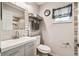 Updated bathroom with wood look tile accent wall, modern vanity, and natural light at 8823 Aruba Ln, Port Richey, FL 34668