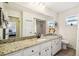 Bright bathroom features large mirror, white cabinets, and granite counters at 8823 Aruba Ln, Port Richey, FL 34668