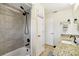 Bathroom featuring updated tiled shower with black matte fixtures, white cabinets and granite counters at 8823 Aruba Ln, Port Richey, FL 34668