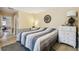 A light and airy bedroom with tile floors, neutral paint, and view to the home's bathroom and walk-in closet at 8823 Aruba Ln, Port Richey, FL 34668