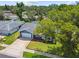 Charming single-story blue home featuring a well-manicured lawn and a spacious two car driveway at 8823 Aruba Ln, Port Richey, FL 34668