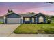 Charming single-story home featuring a well-manicured lawn, blue exterior, and a two-car garage at 8823 Aruba Ln, Port Richey, FL 34668