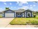 Charming single-story home featuring a well-manicured lawn, blue exterior, and a two-car garage at 8823 Aruba Ln, Port Richey, FL 34668