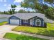 Inviting single-story home with a well-kept lawn, and a two-car garage with a blue exterior paint at 8823 Aruba Ln, Port Richey, FL 34668
