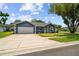 Inviting single-story home with a well-kept lawn, and a two-car garage with a blue exterior paint at 8823 Aruba Ln, Port Richey, FL 34668