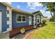Lovely single-story home with a nice front porch and an attractive blue exterior with beautiful landscaping at 8823 Aruba Ln, Port Richey, FL 34668