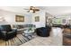 Comfortable living room with a large sofa, stylish decor, ceiling fan and tile flooring at 8823 Aruba Ln, Port Richey, FL 34668
