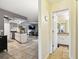 Hallway view of kitchen and living area, features white cabinets and updated lighting at 8823 Aruba Ln, Port Richey, FL 34668