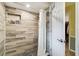 Modern shower with updated tile work, recessed storage, and glass door at 8823 Aruba Ln, Port Richey, FL 34668