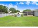Spacious backyard featuring a pool, pool house, enclosed patio, white fence and lush greenery at 901 Strawberry Ln, Brandon, FL 33511