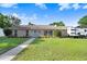 Charming single-story home with stone exterior, blue door, lush lawn, and convenient RV parking at 901 Strawberry Ln, Brandon, FL 33511