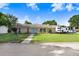 Charming single-story home with stone exterior, blue door, lush lawn, and convenient RV parking at 901 Strawberry Ln, Brandon, FL 33511
