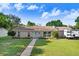 Charming single-story home featuring a well-maintained lawn and stone accents under a sunny, blue sky at 901 Strawberry Ln, Brandon, FL 33511