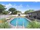 Backyard pool area with patio, pool house, white fence, and mature trees creating a private oasis at 901 Strawberry Ln, Brandon, FL 33511