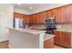 Well-lit kitchen with stainless steel appliances, granite countertops, and wooden cabinets at 9067 39Th Street E Cir, Parrish, FL 34219