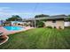Expansive backyard with pool, covered patio, and manicured lawn offers space for recreation and leisure at 11236 116Th St, Largo, FL 33778