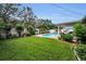 Expansive backyard with a well-maintained lawn, privacy fence, beautiful landscaping, and in-ground pool at 11236 116Th St, Largo, FL 33778