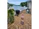 Backyard area featuring a stone base, palm tree, stepping stones, white fence, and outdoor equipment at 11236 116Th St, Largo, FL 33778
