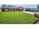 Charming brick home featuring lush green lawn, well-manicured landscaping, and a convenient garage at 11236 116Th St, Largo, FL 33778