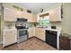 Galley kitchen with stainless steel appliances, tile backsplash, and a window over the sink at 11236 116Th St, Largo, FL 33778