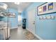 Bright laundry room with washer, dryer, storage shelves, and access to an exterior door at 11236 116Th St, Largo, FL 33778