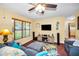 Comfortable living room featuring a large window, ceiling fan and a flat screen television at 11236 116Th St, Largo, FL 33778