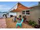 Charming outdoor seating area with retractable awning, landscaping and a view of the backyard at 11236 116Th St, Largo, FL 33778