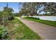 A serene street view featuring lush greenery, mature trees, and a glimpse of residences beyond the privacy fence at 11236 116Th St, Largo, FL 33778