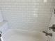 Bathroom features clean white tiles, recessed shelving, and a modern shower faucet at 1137 Highland S St, St Petersburg, FL 33701