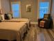 Bedroom features twin beds with neutral bedding, wood floors, and a comfortable reading chair at 1137 Highland S St, St Petersburg, FL 33701