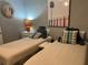 Twin bedroom showcases neutral bedding, side table with a lamp, and eye-catching modern artwork at 1137 Highland S St, St Petersburg, FL 33701