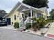Charming yellow home featuring a cozy front porch, lush plants, and white gravel landscaping at 1137 Highland S St, St Petersburg, FL 33701