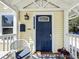 Inviting front porch with a navy blue door, white trim, and a cozy seating area, creating a warm entry at 1137 Highland S St, St Petersburg, FL 33701