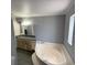 Bathroom featuring a sunken tub, vanity and mirror at 12319 Memorial Hwy, Tampa, FL 33635