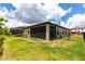 Enclosed backyard with a screened porch, fence, and green lawn, providing privacy at 12646 Oak Hill Way, Parrish, FL 34219