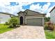 Charming single-story home featuring a brick driveway, attached garage, and manicured lawn at 12646 Oak Hill Way, Parrish, FL 34219