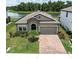 Charming single-story home featuring a brick driveway and a well-manicured front lawn with water view at 12646 Oak Hill Way, Parrish, FL 34219