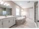 Luxurious bathroom with a soaking tub, double vanities, and a walk-in shower at 12646 Oak Hill Way, Parrish, FL 34219